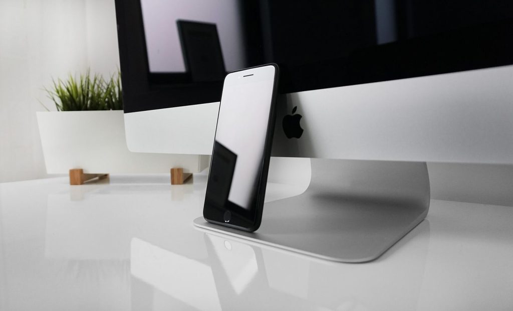 Smartphone next to a computer used to research a landlord