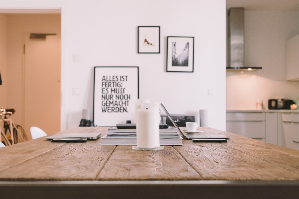 Wood table in front of white wall (Unsplash)