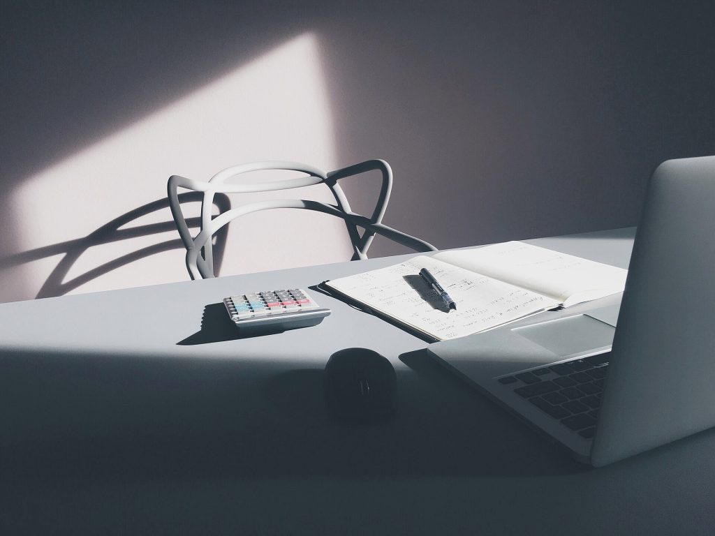 Desktop with laptop and calculator (Unsplash)